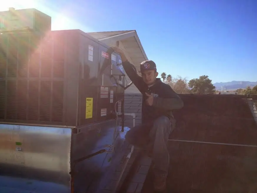 HVAC technician performing AC Tune-Up on a rooftop unit in Savannah